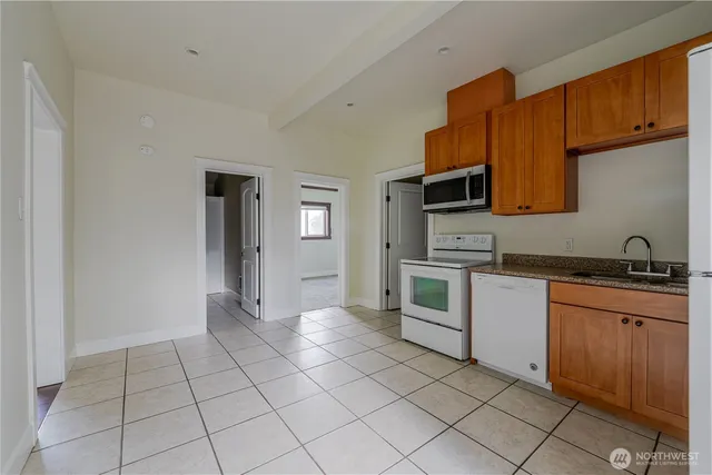 a kitchen with stainless steel appliances granite countertop a stove top oven a sink and dishwasher