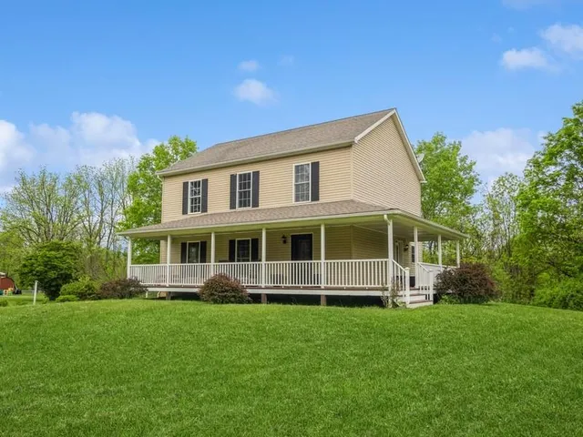 a front view of a house with a yard and trees