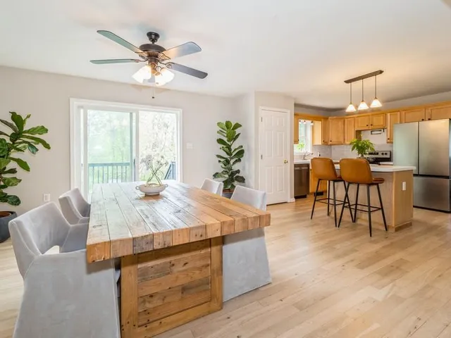a dining room with wooden floor a chandelier a wooden table and chairs