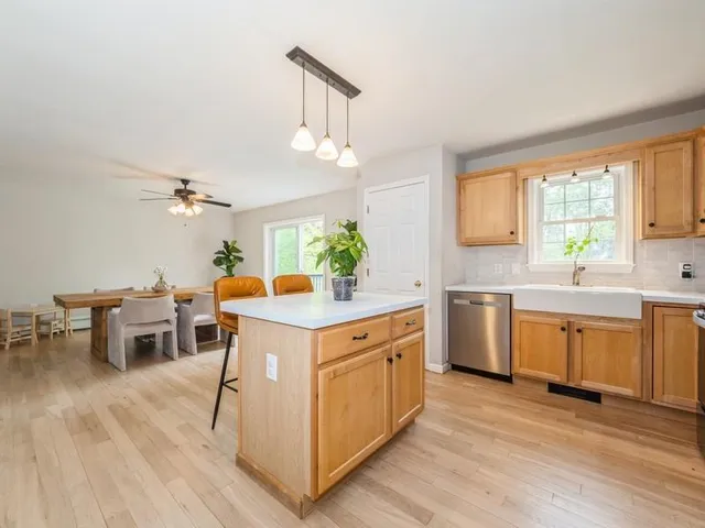a kitchen with a sink stove cabinets and wooden floor