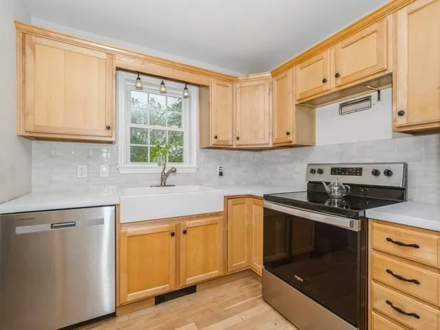 a kitchen with stainless steel appliances granite countertop a sink a stove and cabinets