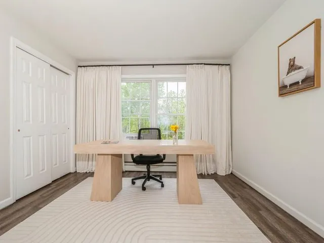 a view of a workspace with furniture and a window