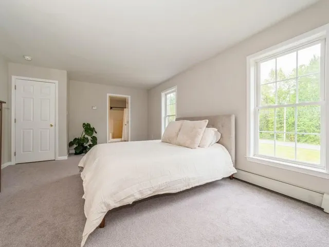 a large bed sitting in a bedroom next to a window