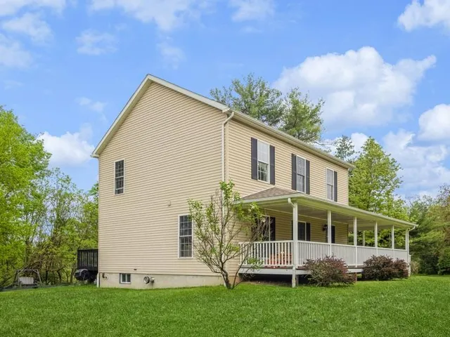 a front view of a house with a garden and trees