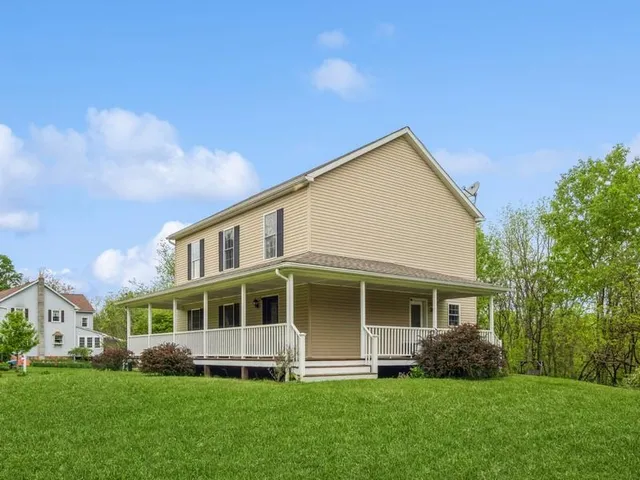 a front view of a house with a yard and green space