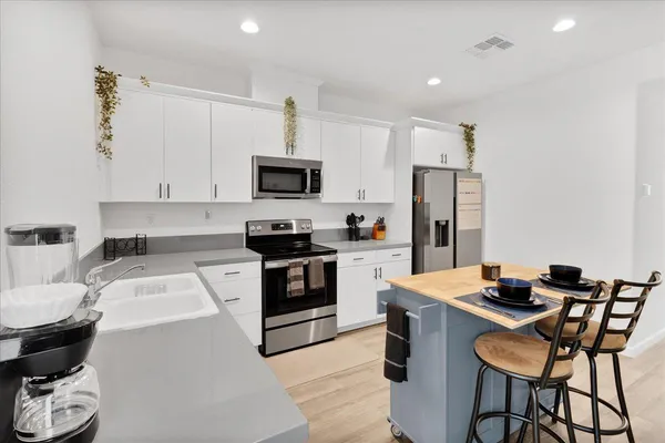 a kitchen with white cabinets and appliances