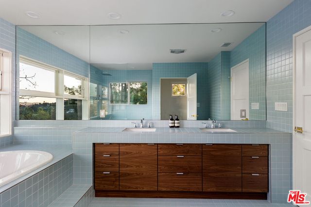 a bathroom with a granite countertop sink mirror and bathtub