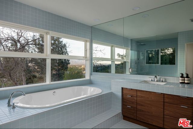 a bathroom with a large tub sink and window