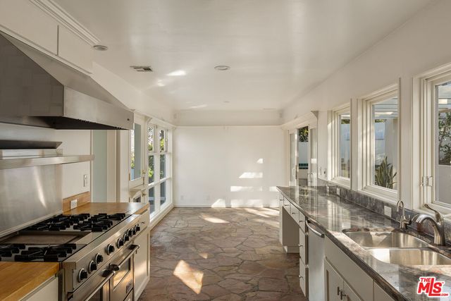 a kitchen with stainless steel appliances granite countertop a sink stove and cabinets