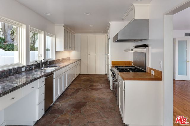 a kitchen with granite countertop a sink stove and refrigerator