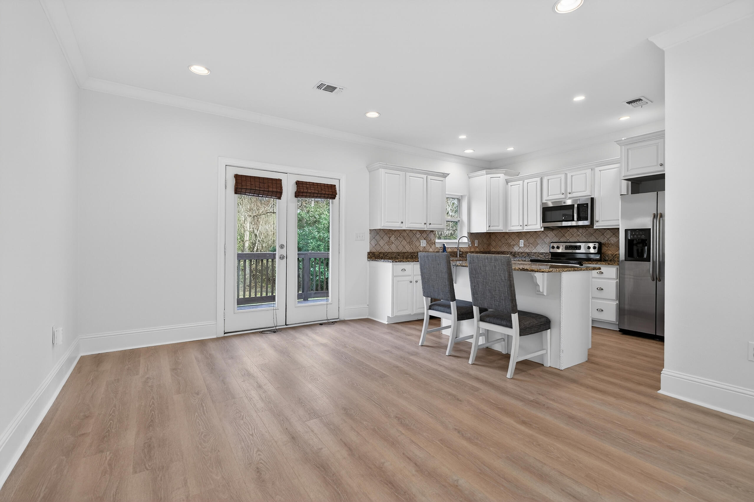 159 7th Street Santa Rosa Beach, FL 32459 - Photo 18 of 53 a kitchen with stainless steel appliances granite countertop a stove top oven a sink and white cabinets with wooden floor