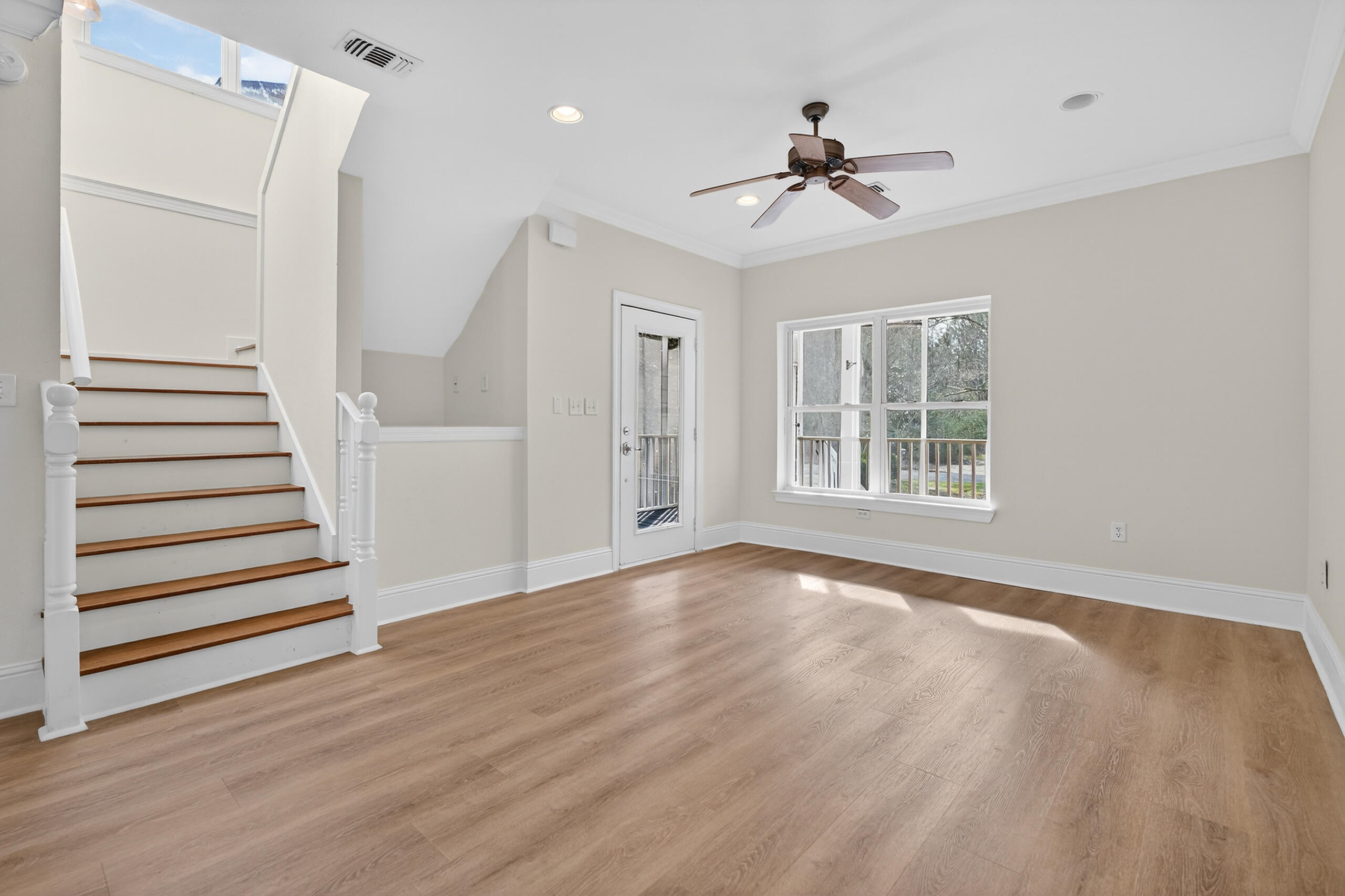 159 7th Street Santa Rosa Beach, FL 32459 - Photo 4 of 53 a view of an empty room with wooden floor ceiling fan and windows