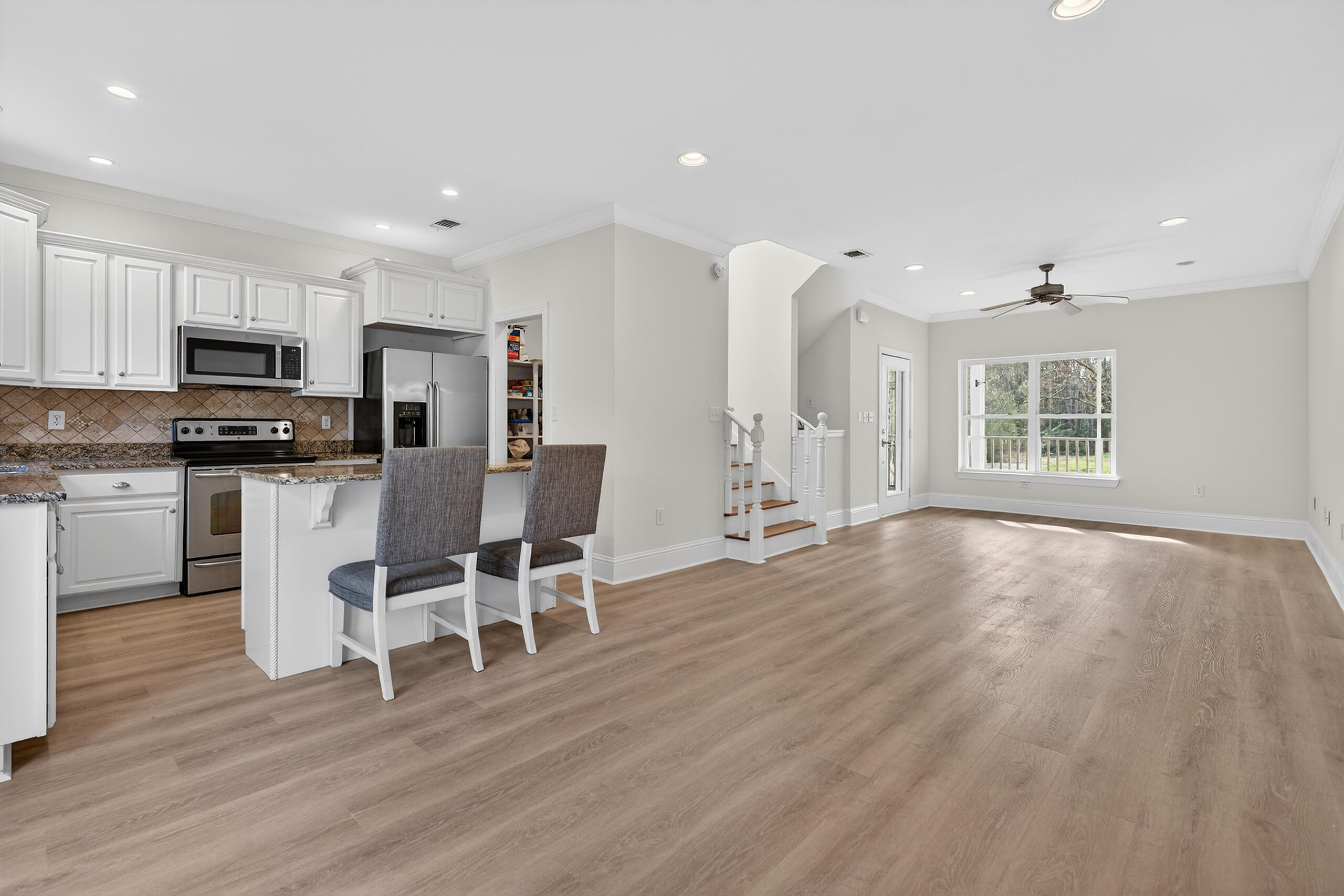159 7th Street Santa Rosa Beach, FL 32459 - Photo 8 of 53 a kitchen with stainless steel appliances granite countertop a stove top oven a sink dishwasher a dining table and chairs with wooden floor