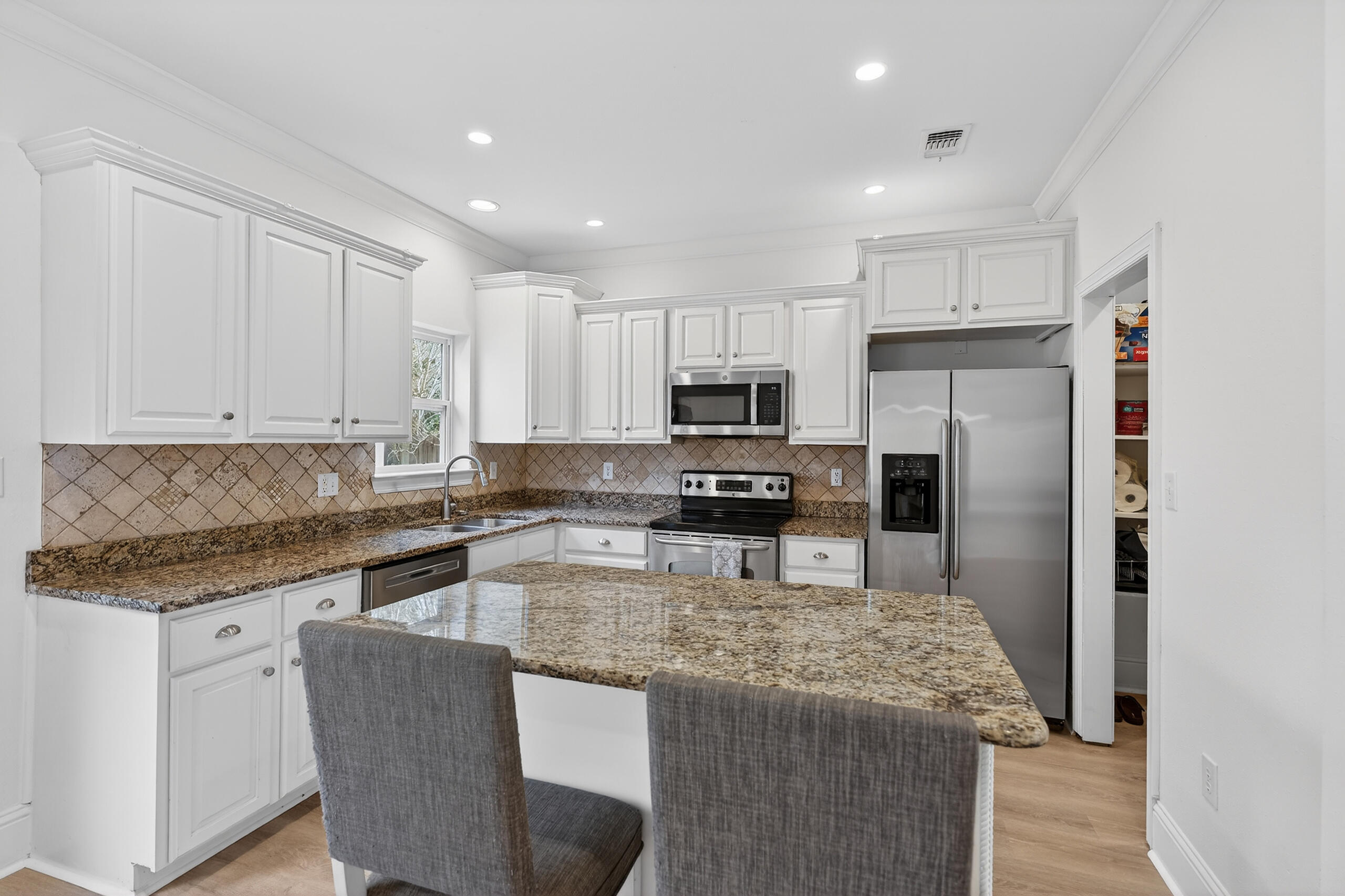 159 7th Street Santa Rosa Beach, FL 32459 - Photo 9 of 53 a kitchen with kitchen island granite countertop wooden cabinets and refrigerator