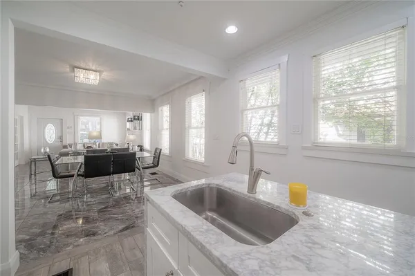 a kitchen with white cabinets sink and stove