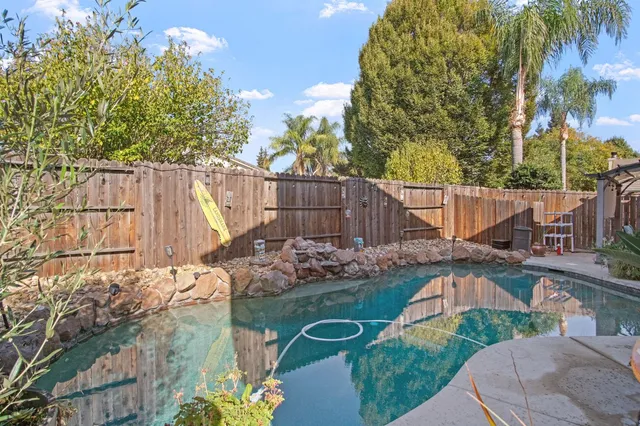 a view of backyard with swimming pool and outdoor seating