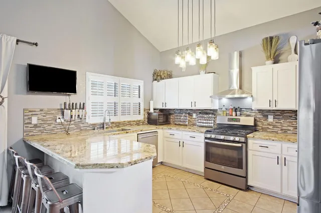 a kitchen with kitchen island granite countertop stainless steel appliances a stove sink microwave and cabinets