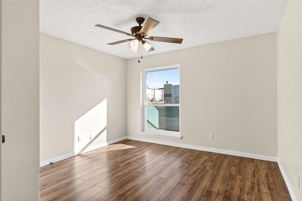 11460 Audelia Road, Unit 287 Dallas, TX 75243 - Photo 26 of 39 Unfurnished room featuring wood finished floors, a textured ceiling, and ceiling fan