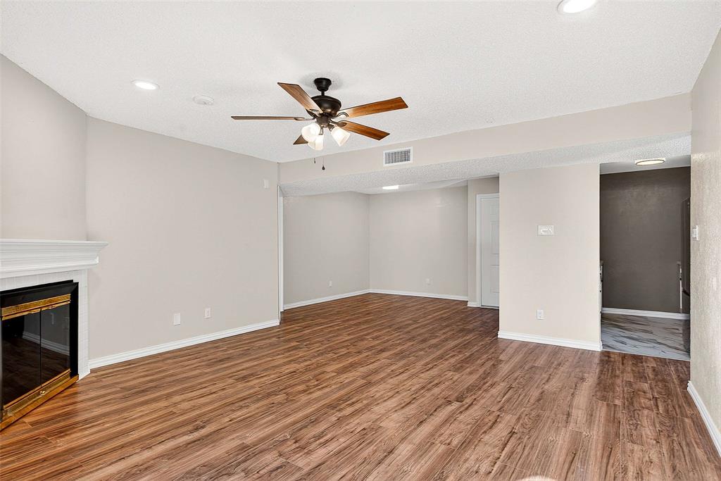 11460 Audelia Road, Unit 287 Dallas, TX 75243 - Photo 5 of 39 Unfurnished living room featuring a tiled fireplace, ceiling fan, light wood-style floors, and recessed lighting