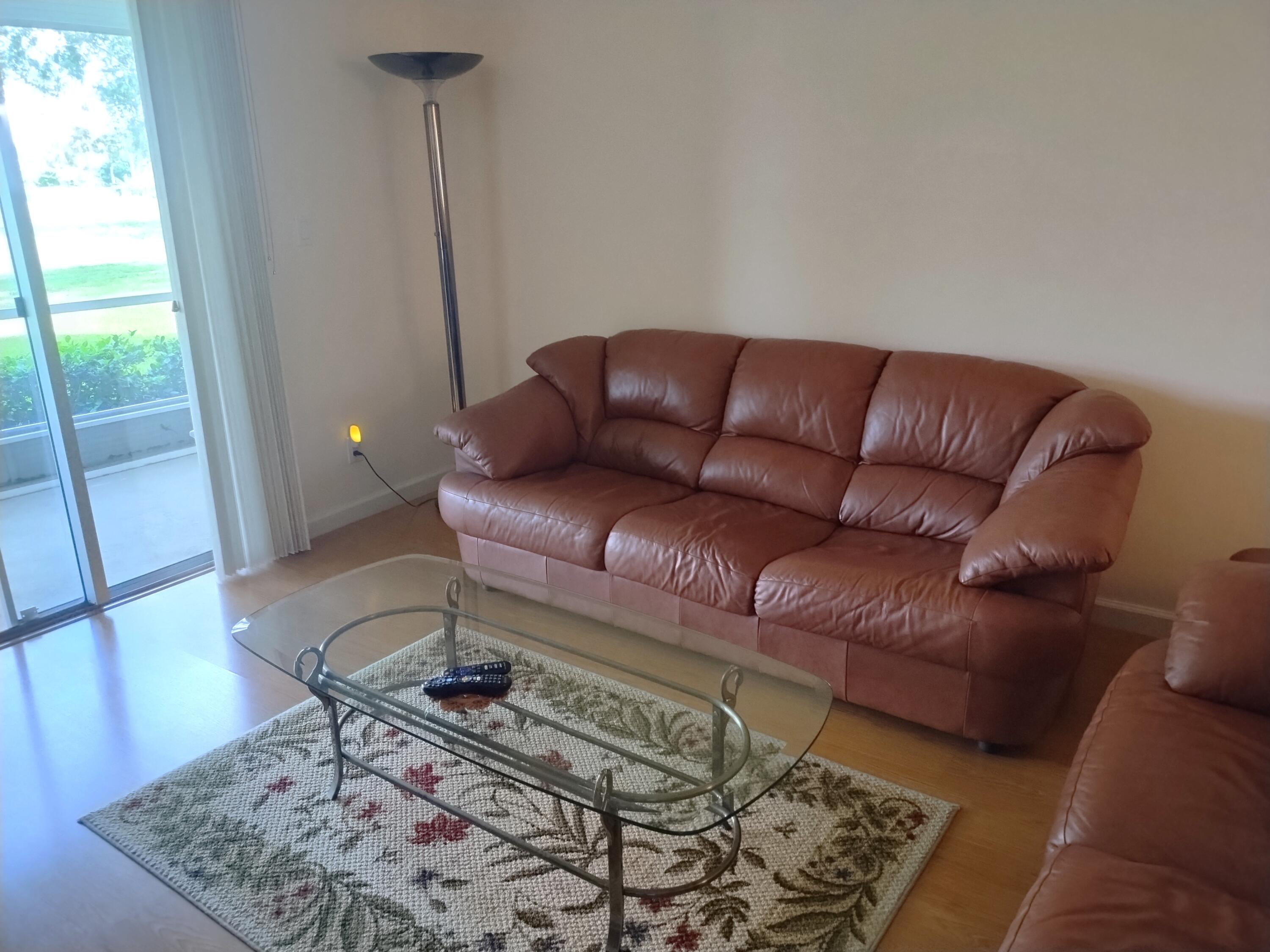 6461 Northwest 2nd Avenue, Unit 102 Boca Raton, FL 33487 - Photo 2 of 30 a living room with a couch and a rug