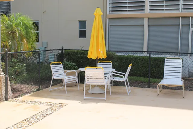 a view of a patio with a table and chairs and potted plants