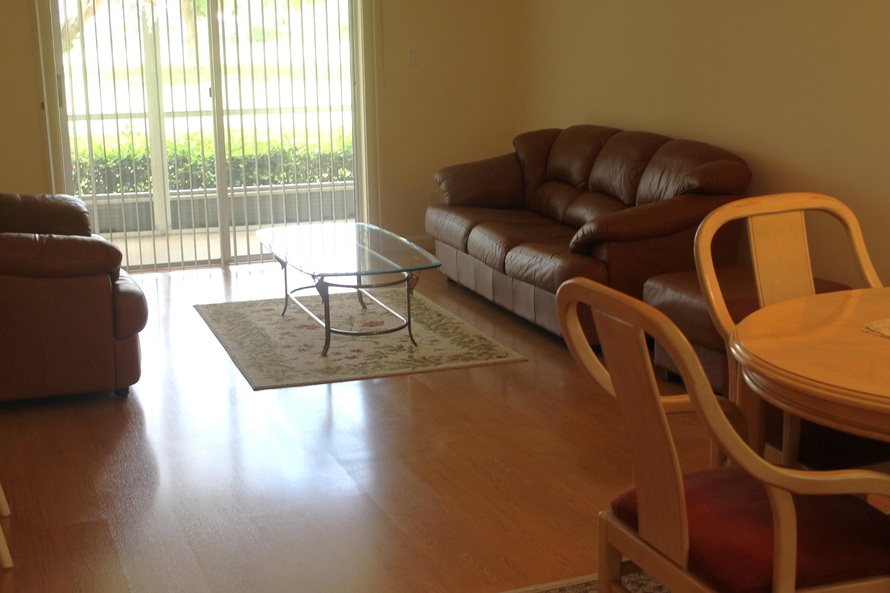 6461 Northwest 2nd Avenue, Unit 102 Boca Raton, FL 33487 - Photo 3 of 30 a living room with furniture and a floor to ceiling window