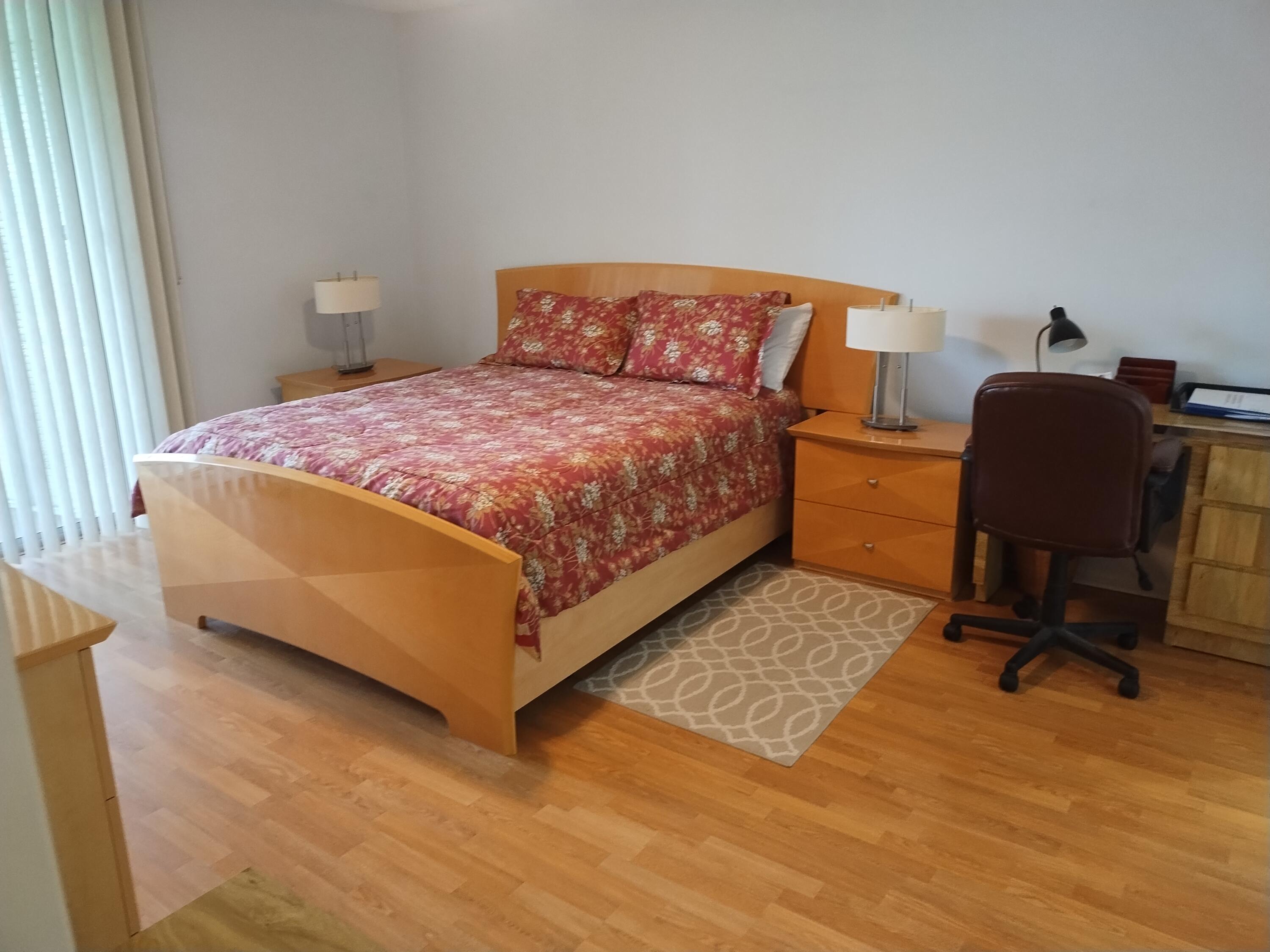 6461 Northwest 2nd Avenue, Unit 102 Boca Raton, FL 33487 - Photo 7 of 30 a bedroom with a bed a chair and a dresser next to a window