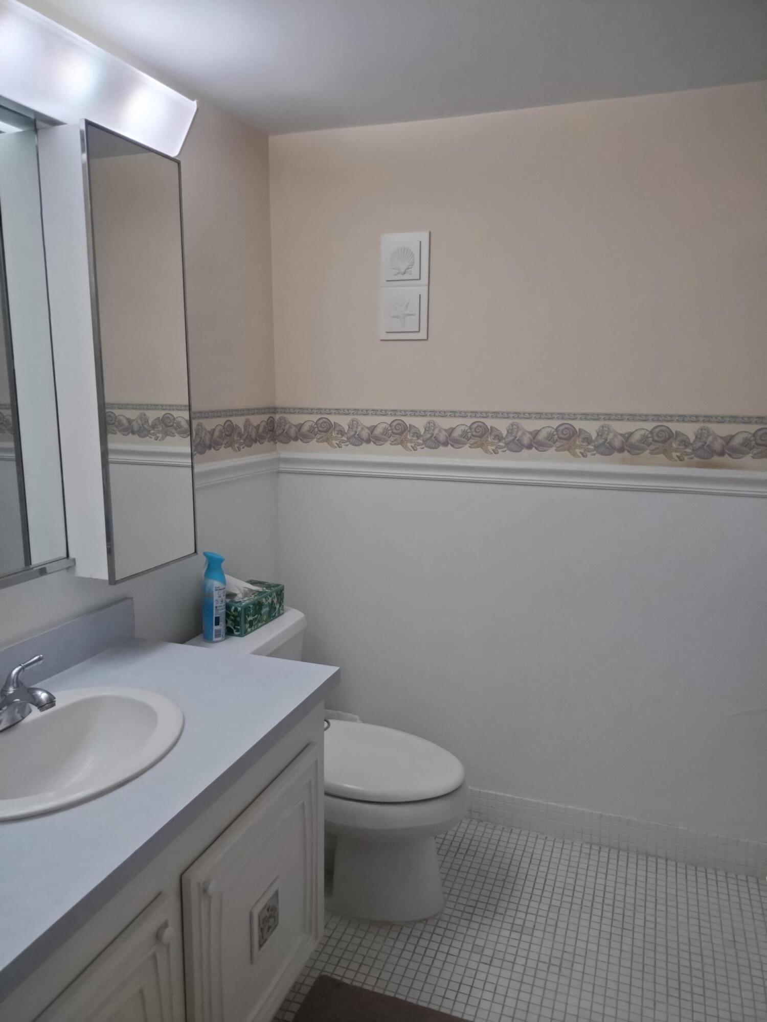 6461 Northwest 2nd Avenue, Unit 102 Boca Raton, FL 33487 - Photo 10 of 30 a bathroom with a granite countertop toilet sink and mirror