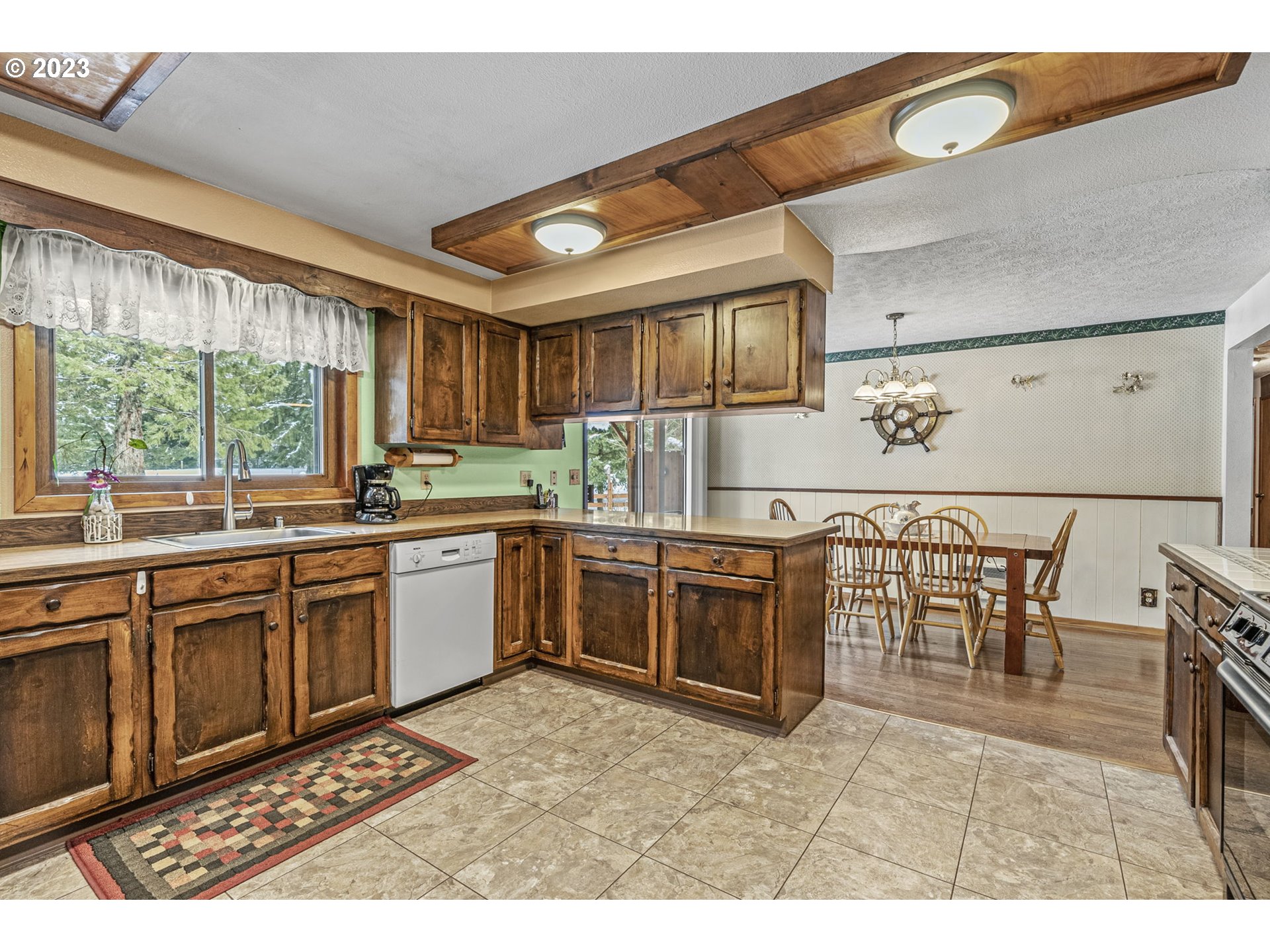 71 Stevens Road Washougal, WA 98671 - Photo 12 of 32 a kitchen with granite countertop a stove a sink a dining table and chairs