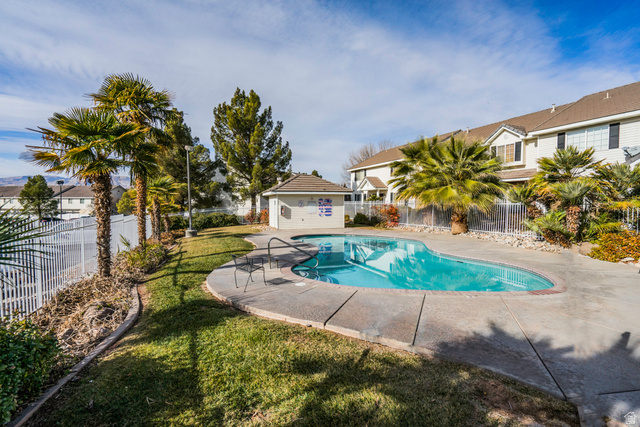 1735 West 540 North, Unit 1805 St. George, UT 84770 - Photo 64 of 64 Freeform swimming pool with concrete decking, surrounded by mature palm trees and manicured lawn