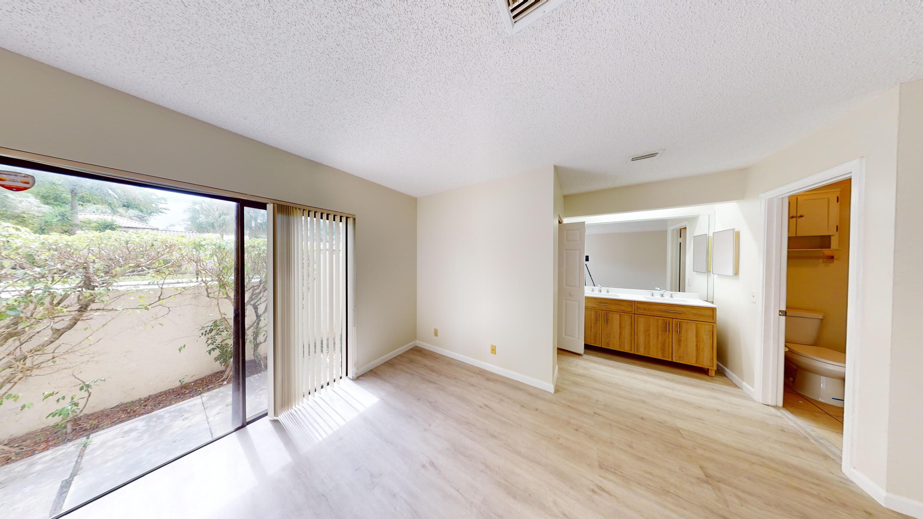 3149 Kingswood Terrace Boca Raton, FL 33431 - Photo 13 of 16 a view of an empty room with wooden floor and a window