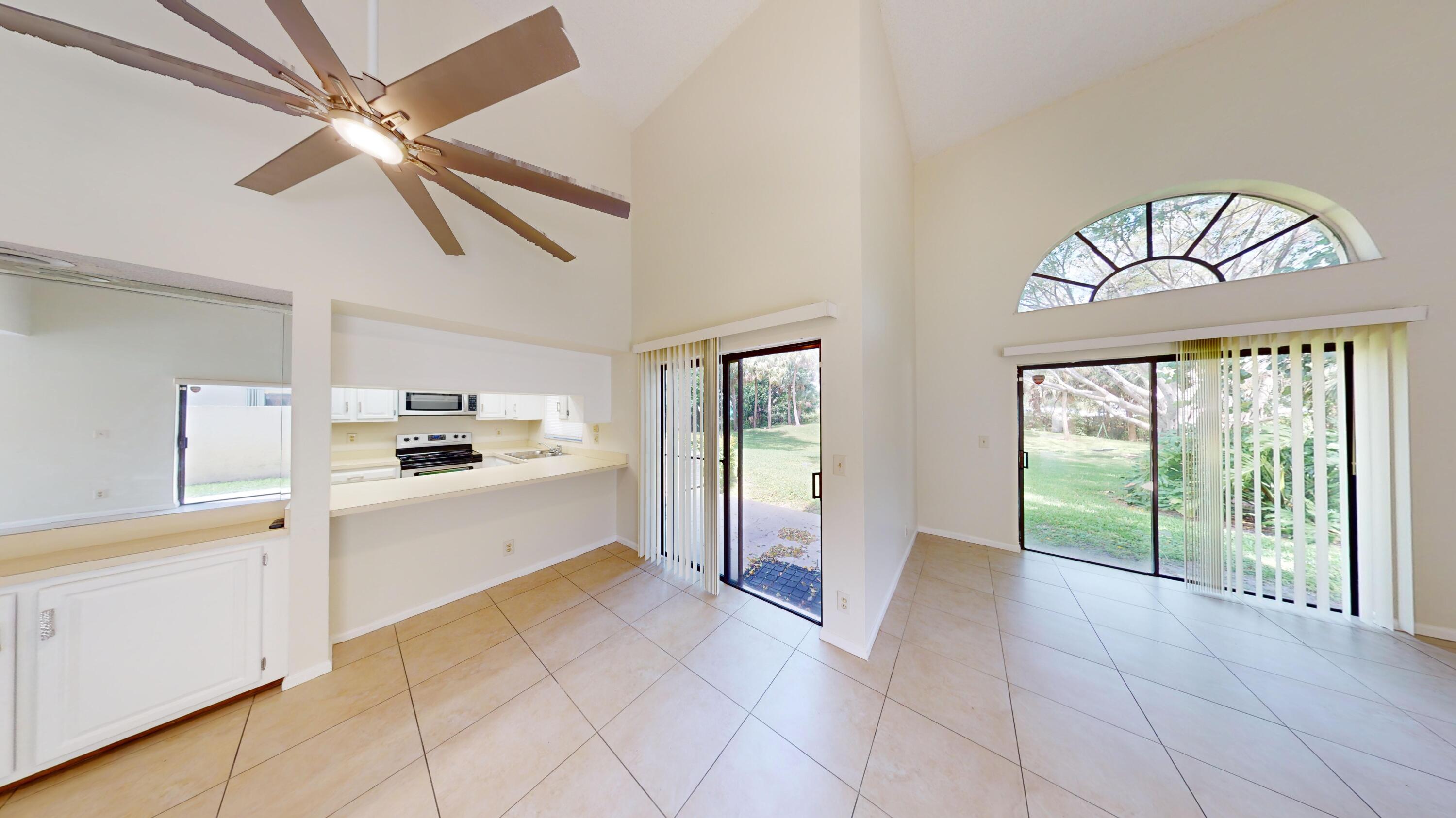 3149 Kingswood Terrace Boca Raton, FL 33431 - Photo 5 of 16 a large white kitchen with a large window a refrigerator and stainless steel appliances