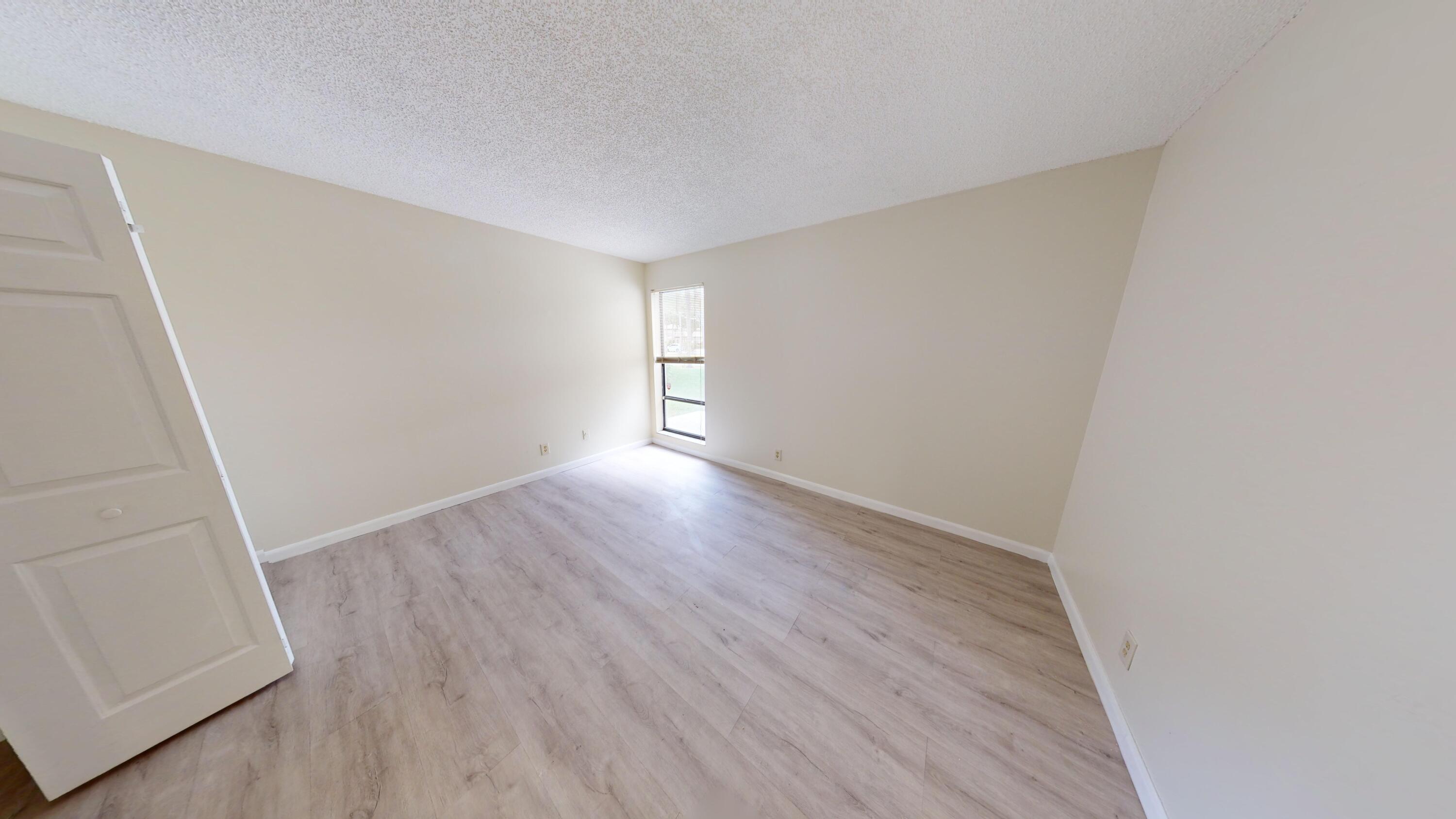 3149 Kingswood Terrace Boca Raton, FL 33431 - Photo 8 of 16 an empty room with wooden floor and windows