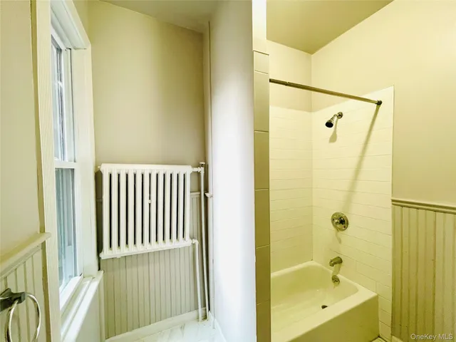 a bathroom with a tub shower and sink
