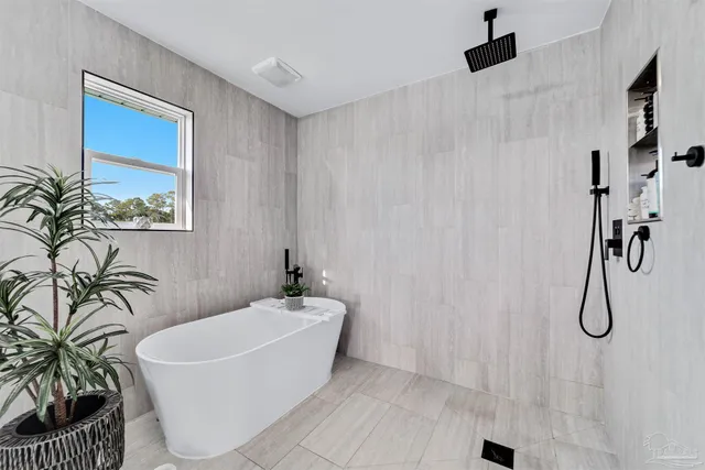 a white bath tub sitting next to a white sink and a shower