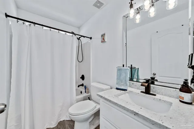 a bathroom with a sink a toilet and shower curtain