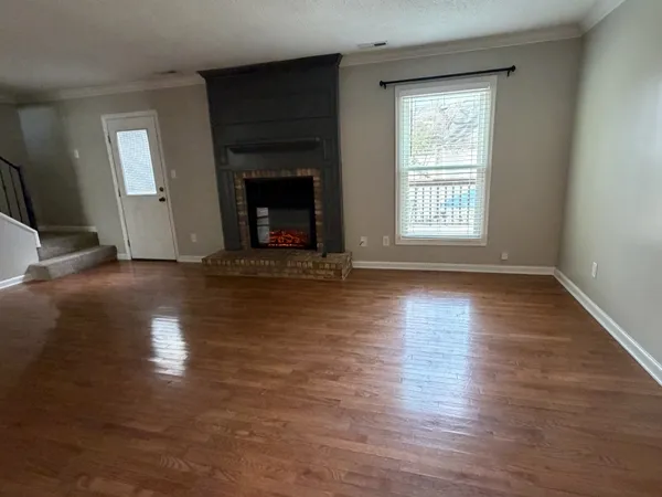 a view of empty room with wooden floor and fireplace