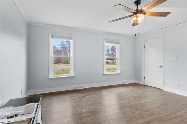 a view of an empty room with a window and a ceiling fan