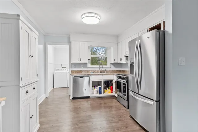 a kitchen with stainless steel appliances a refrigerator sink and cabinets