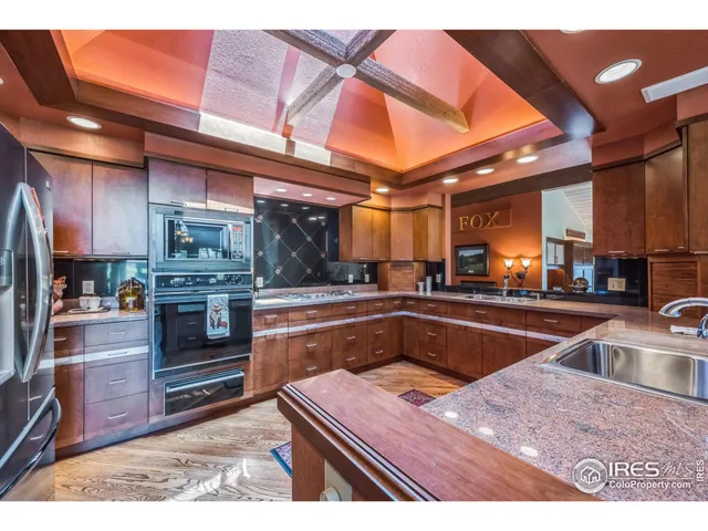 a kitchen with stainless steel appliances granite countertop a sink and a refrigerator
