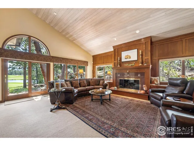 a living room with furniture a fireplace and a large window