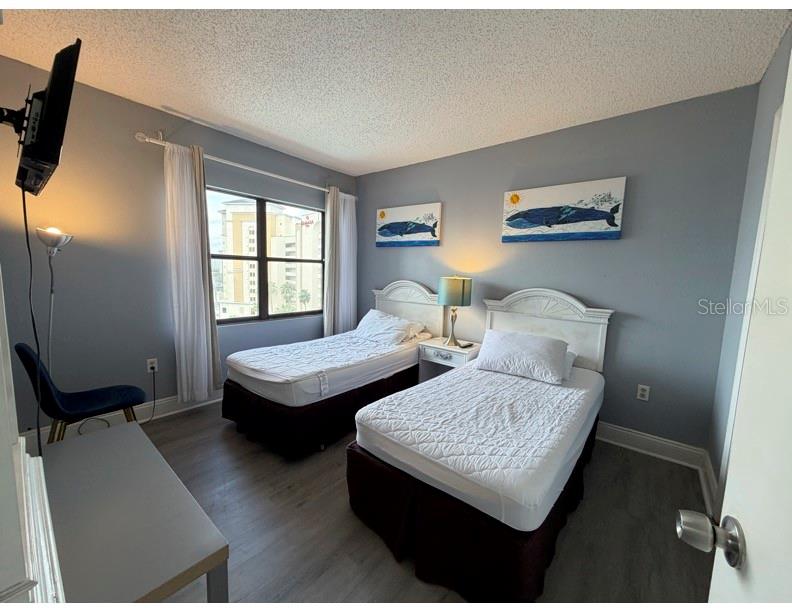 6165 Carrier Drive, Unit 1903 Orlando, FL 32819 - Photo 11 of 21 a bedroom with two beds and a dresser