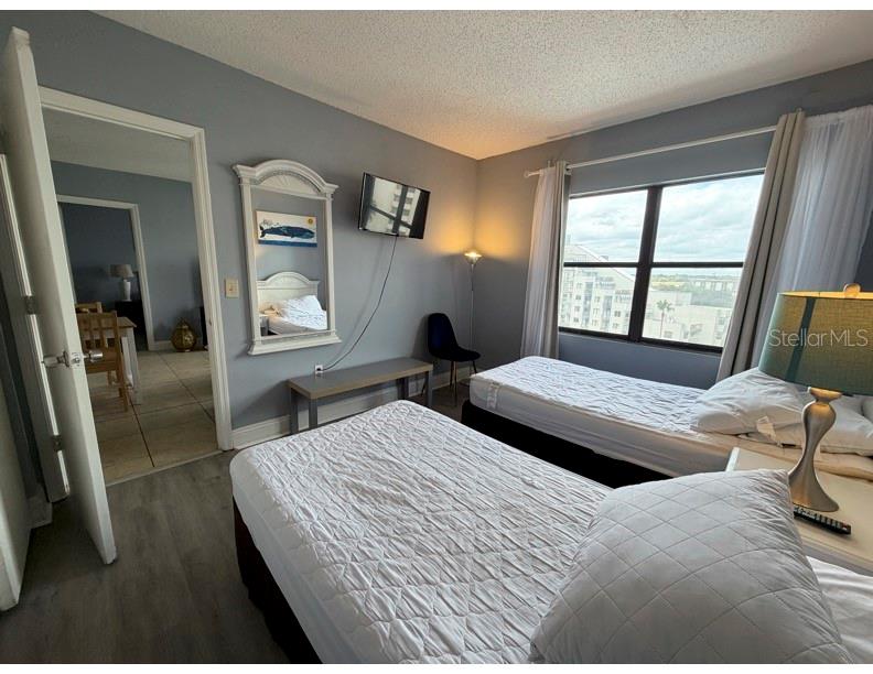 6165 Carrier Drive, Unit 1903 Orlando, FL 32819 - Photo 12 of 21 a bedroom with two beds and a large mirror