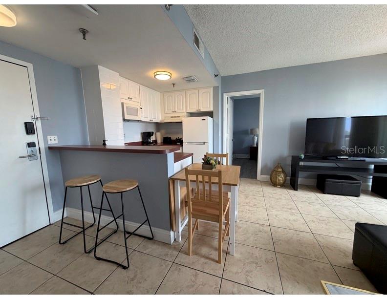 6165 Carrier Drive, Unit 1903 Orlando, FL 32819 - Photo 2 of 21 a kitchen with stainless steel appliances a kitchen island microwave and cabinets