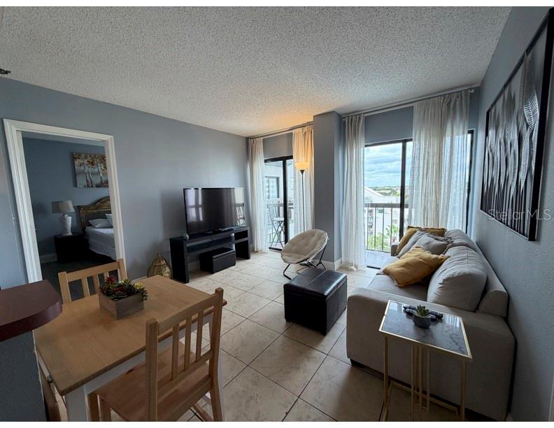 6165 Carrier Drive, Unit 1903 Orlando, FL 32819 - Photo 3 of 21 a living room with furniture and a flat screen tv