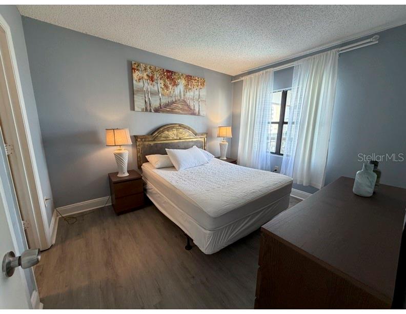 6165 Carrier Drive, Unit 1903 Orlando, FL 32819 - Photo 7 of 21 a bedroom with a bed and a table in it