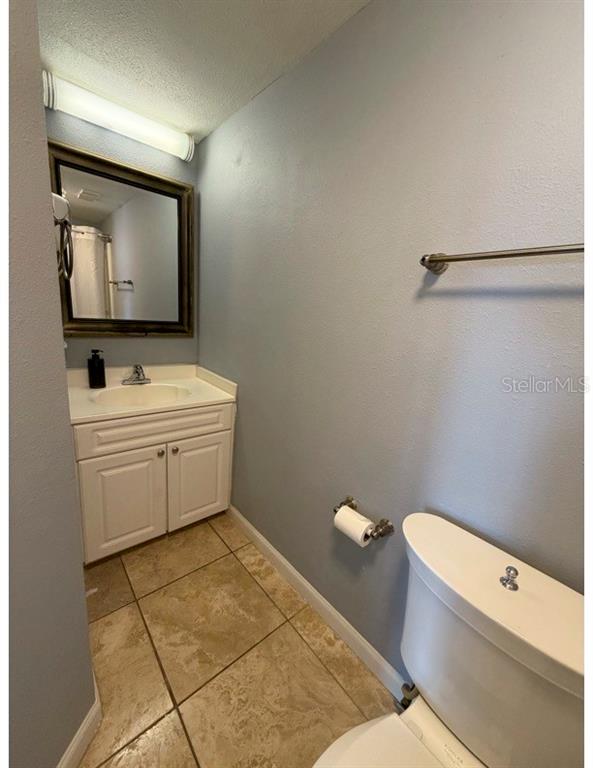 6165 Carrier Drive, Unit 1903 Orlando, FL 32819 - Photo 9 of 21 a bathroom with a toilet sink and mirror