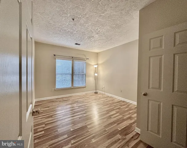 a view of a room with wooden floor and brick walls