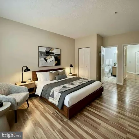 a bedroom with bed a mirror and a table