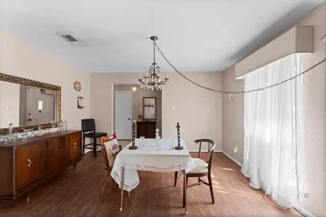 a view of a a dining room with furniture window and wooden floor